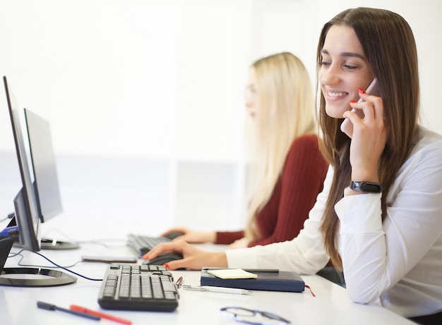 Dos colegas femeninas en la oficina trabajando juntos.