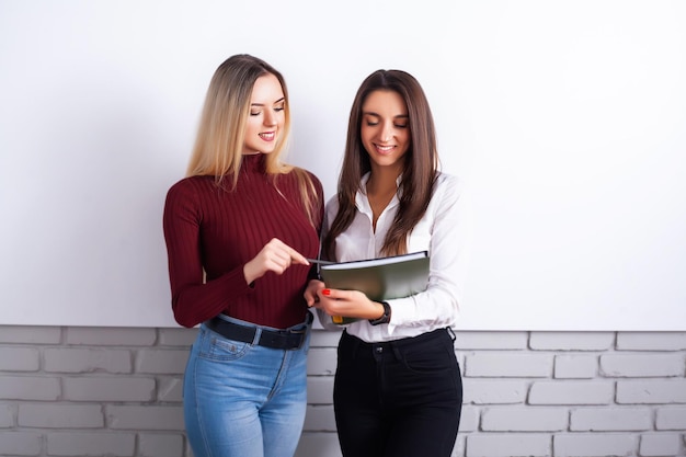 Foto dos colegas femeninas en la oficina trabajando juntos