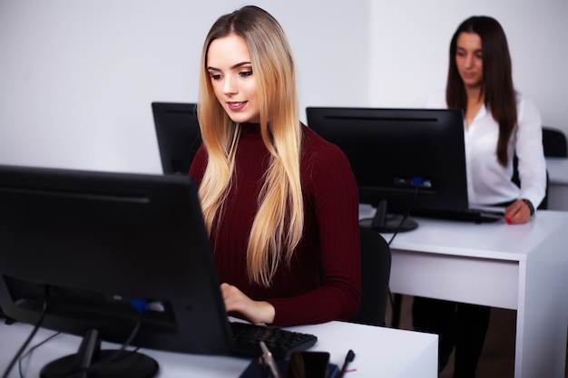 Dos colegas femeninas en la oficina trabajando juntos.