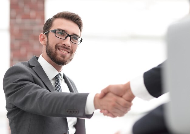 Dos colegas de negocios dándose la mano durante la reunión