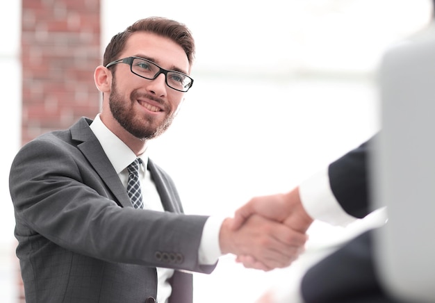 Dos colegas de negocios dándose la mano durante la reunión