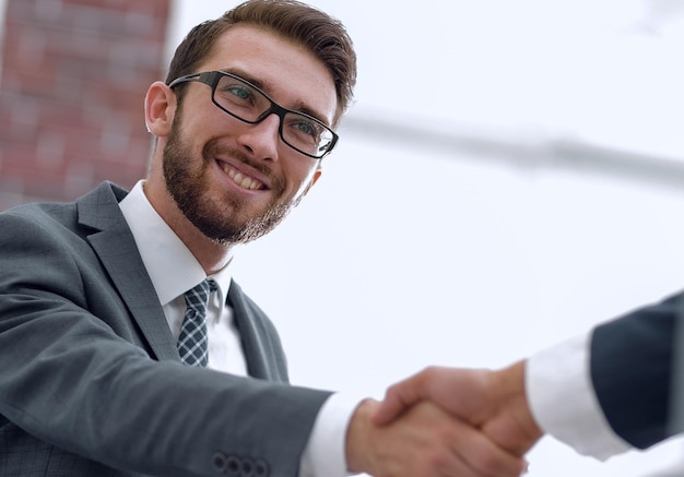 Dos colegas de negocios dándose la mano durante la reunión