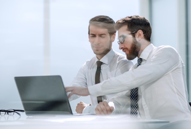 Dos colegas de negocios discuten la información sentada en la foto del escritorio con espacio para copiar