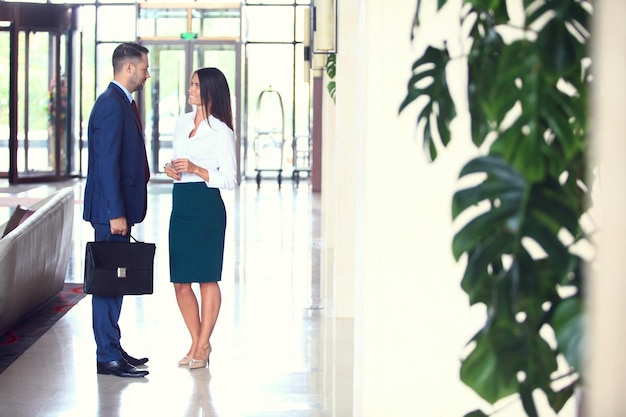 Dos colegas de negocios en una reunión en el interior de una oficina moderna