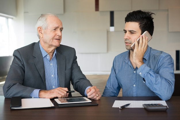 Dos colegas serios discutiendo el proyecto en curso