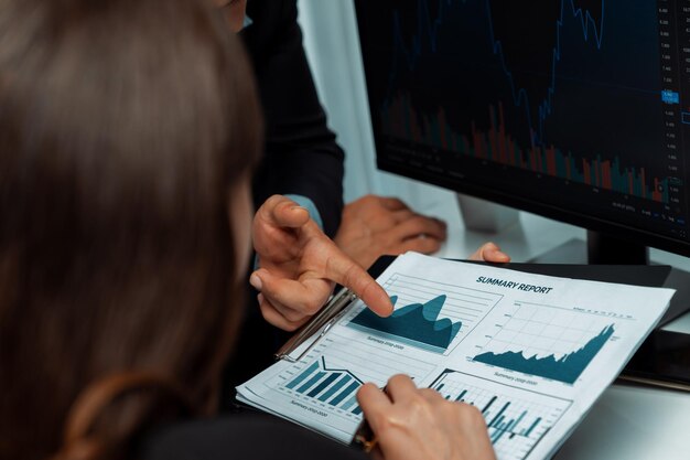 Foto dos comerciantes de negocios discutiendo las estadísticas empresariales sobre el postulado del papel de informe