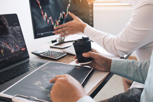 Dos compañeros de trabajo de asociación de negocios analizan la estrategia y gesticulan discutiendo un plan financiero