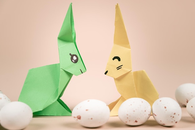 Dos conejitos de origami de papel y un huevo de Pascua