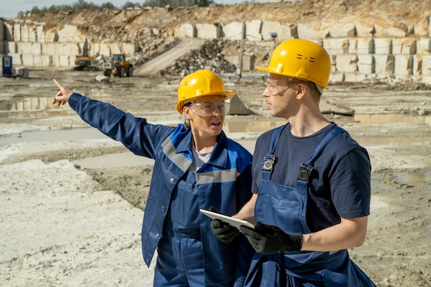 Dos constructores en ropa de trabajo con discusión en el lugar de trabajo