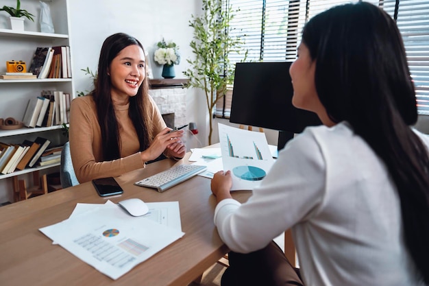 Dos contadoras tienen una reunión de equipo para resumir la información financiera en la oficina