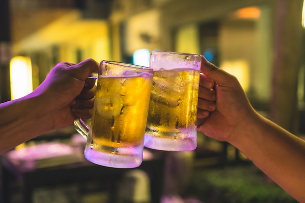 Dos copas de cerveza se animan entre amigos en el bar y restaurante de poca luz