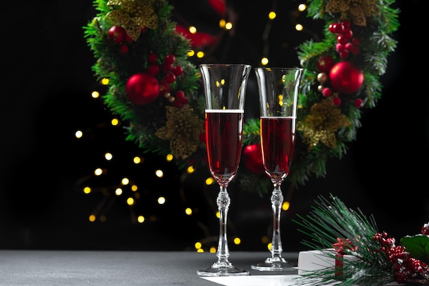 Dos copas de champán llenas en el contexto de una corona de navidad babbo natale uvlin uvgun j