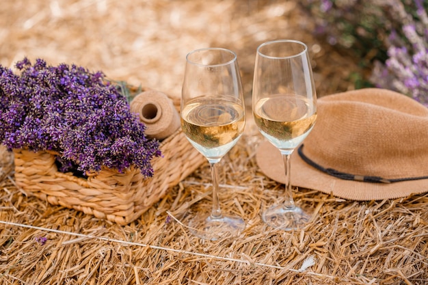 Dos copas de vino blanco en un campo de lavanda en Provance Flores violetas en el fondo