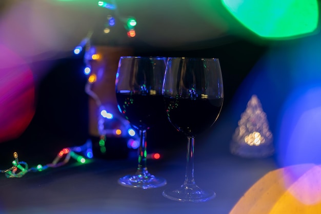 Dos copas de vino en un brillante guirnalda bokeh sobre un fondo negro