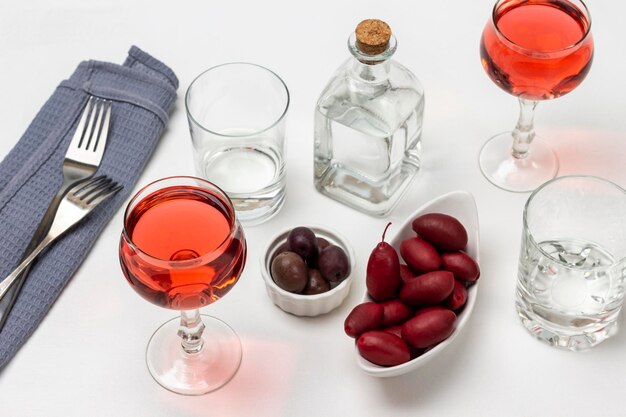 Foto dos copas de vino rosado aceitunas en un plato blanco
