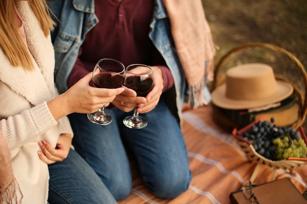 Foto dos copas de vino tinto en la mano en una cita.