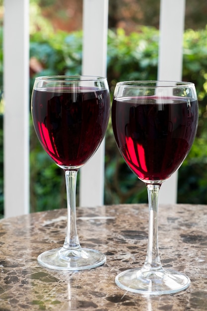 Dos copas de vino tinto en una mesa. Al aire libre