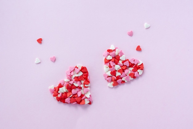 Foto dos corazones de corazoncitos de azúcar rojo, blanco y rosa