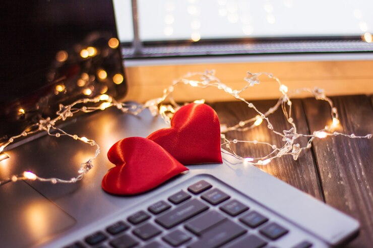 Foto dos corazones rojos se encuentran en una mesa de madera cerca de una computadora portátil, amor de la boda del día de san valentín