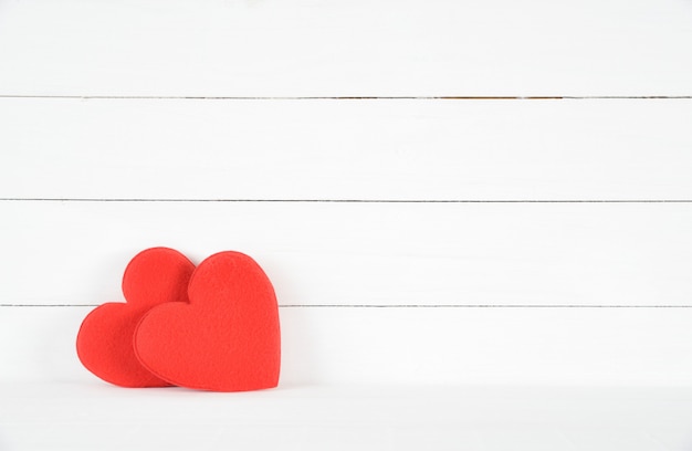 Dos corazones rojos sobre fondo blanco de madera. Concepto de amor Día de San Valentín. Concepto de salud