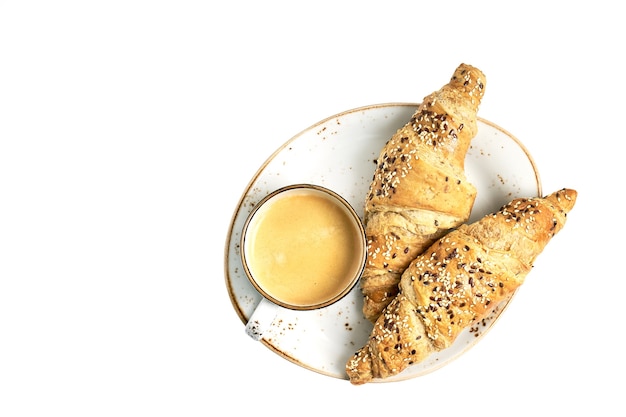 Dos croissant y una taza de café aisladas sobre fondo blanco. Vista superior, espacio de copia