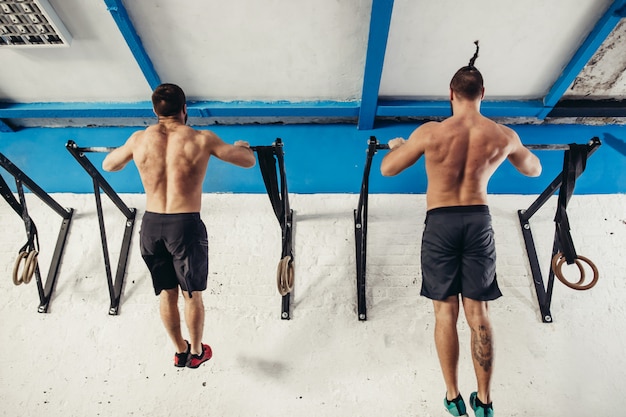 Foto dos dedos del pie para entrenar a los hombres pull-ups barras de árboles ejercicio de entrenamiento en el gimnasio