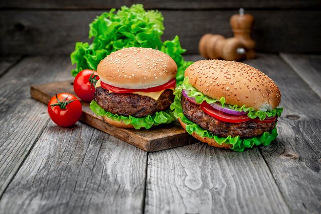 Dos deliciosas hamburguesas caseras de ternera en una mesa de madera vieja Primer plano de alimentos poco saludables