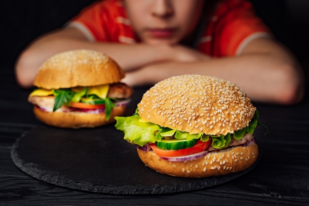 Dos deliciosas hamburguesas con tomate, ternera, pepino verde y lechuga