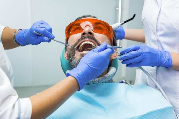 Dos dentistas con manos pacientes de médicos con guantes