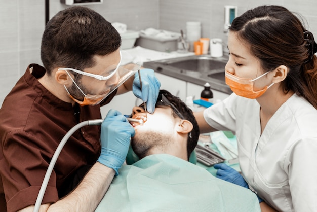 Dos dentistas tratan a un paciente.