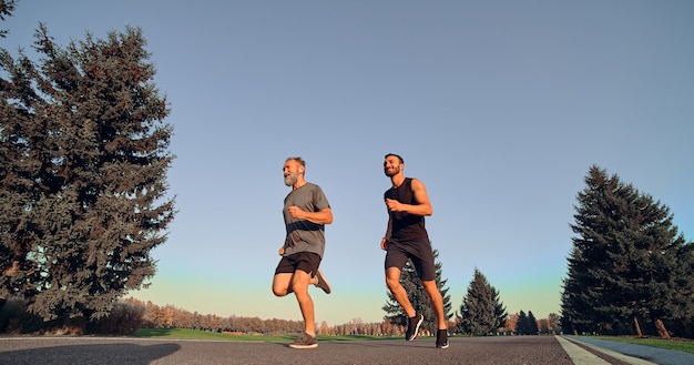 Los dos deportistas corriendo por el callejón.