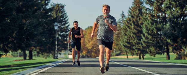 Los dos deportistas corriendo por la carretera.