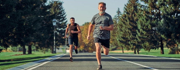 Los dos deportistas corriendo por la carretera.