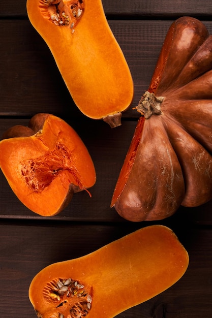 Dos diferentes rebanadas de calabazas naranjas maduras closeup fondo de madera