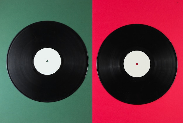 Dos discos de vinilo sobre una superficie verde-roja. Estilo retro.