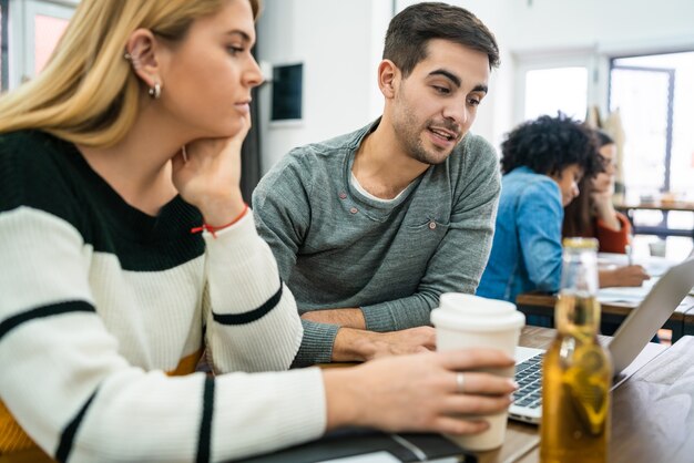 Foto dos diseñadores creativos que trabajan juntos en un proyecto, leen algo en una tableta digital y comparten nuevas ideas en el lugar de trabajo. concepto de negocio y trabajo en equipo.