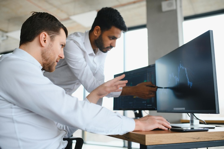 Foto dos diversos corredores de criptocomerciantes inversionistas del mercado bursátil discuten el crecimiento de los informes de investigación de gráficos comerciales usando una computadora pc mirando la pantalla analizando los riesgos financieros de la estrategia de inversión