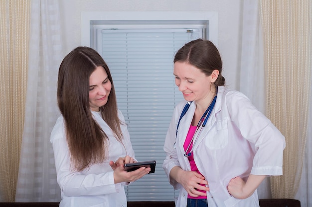 Dos doctoras o enfermeras miran la tableta y discuten la terapia