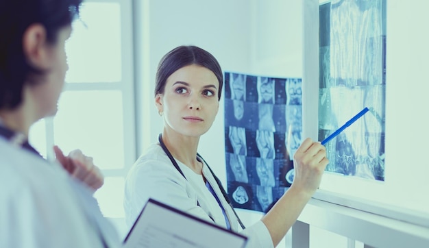 Dos doctoras señalando radiografías en un hospital