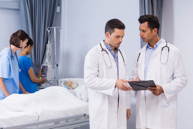 Dos doctores discutiendo informe médico