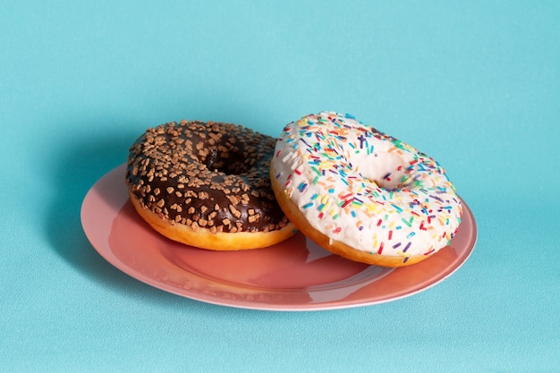 Dos donas en una placa rosa sobre azul