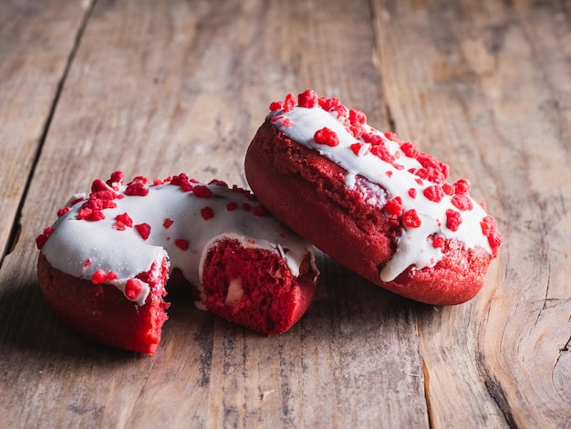 Dos donuts uno mordido sobre un fondo de madera