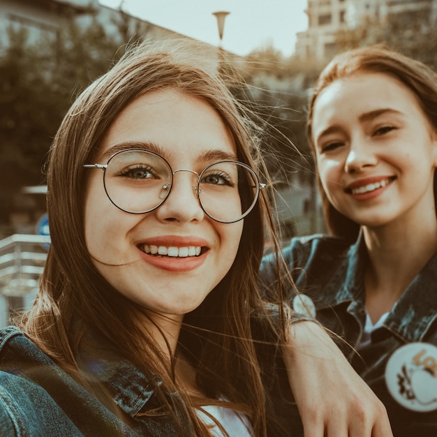 Dos elegantes chicas felices mejores amigas haciendo selfie en Europa