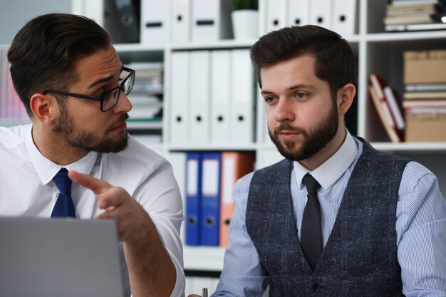 Dos empleados discutiendo un nuevo proyecto en la oficina