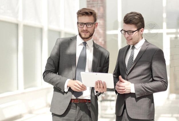 Dos empleados de pie en la oficina.