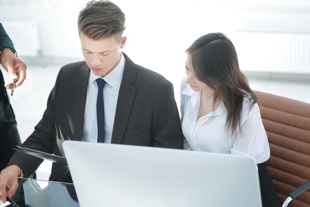 Dos empleados sentados en un escritorio en la oficina.