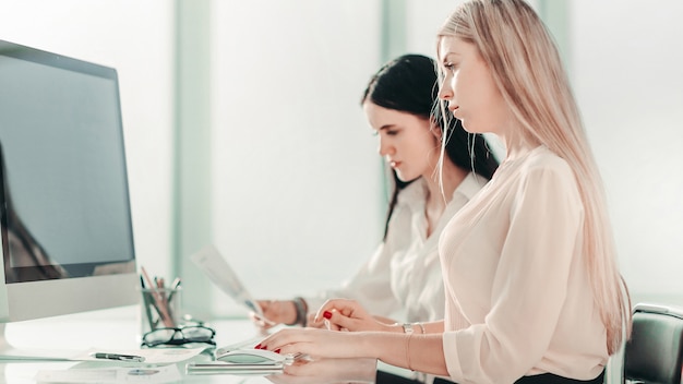 Dos empleados sentados en el escritorio de la oficina