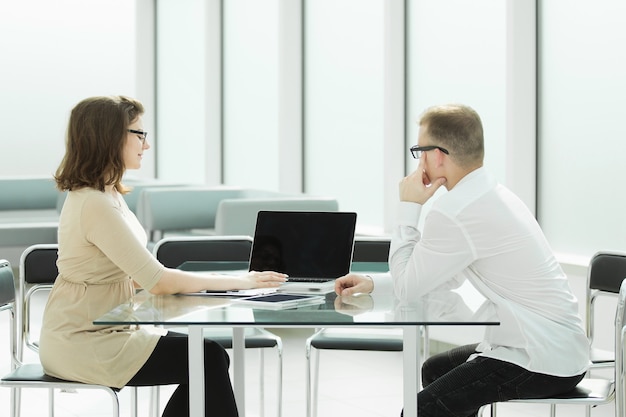 Dos empleados sentados en el escritorio de la oficina