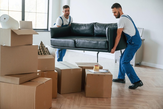 Dos empleados de servicio de mudanzas en una habitación