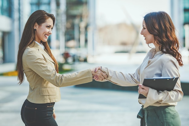 Foto dos empresarias se dan la mano después de un buen trato.